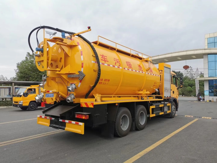 A bright yellow vacuum suction truck with large cylindrical tank and multiple hoses, parked in an urban area. Used as a comperssor to suction out sediment from septic tanks, for unclogging the sewer, and to suction out oil. from ayahkutub.com.