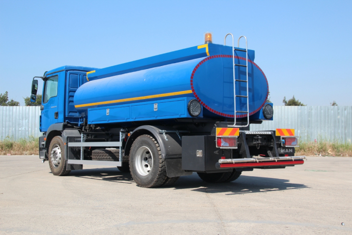  A blue water tanker truck with a cylindrical tank and safety markings, parked on a paved surface under a clear blue sky. Supplying potable water and refined water for irrigation from ayahkutub.com.